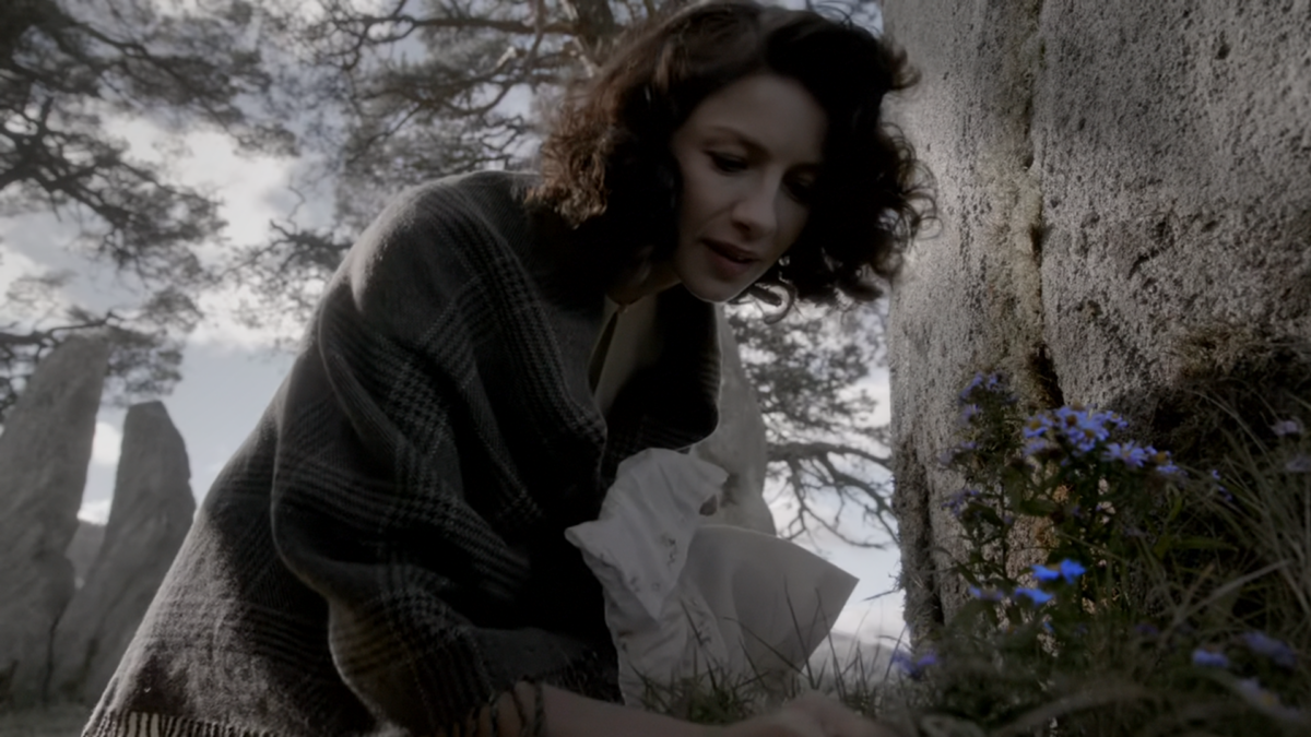 Claire devant les fleurs bleues de Craigh na Dun